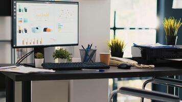 Wheelchair in inclusive office and display showing marketing planning data. Medical chair in workspace offering accessibility to workers with disability and monitor with business analytics photo