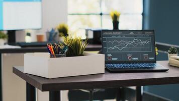 Business forecasting graphs showing profits on laptop in empty office. Economic annual revenue statistics report on notebook screen in accounting department office with no people in photo