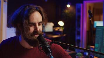 Artist singing a song at microphone and playing electronic piano to create music in home studio. Songwriter recording midi controller sounds, adjusting volume with pore amp knobs. Camera B. photo