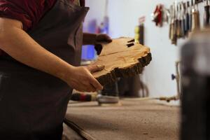 carpintero participación madera bloquear, haciendo calidad garantía en eso antes de comenzando mueble montaje en taller, cerca arriba disparo. fabricante en carpintería preparando pedazo de madera para tallado foto