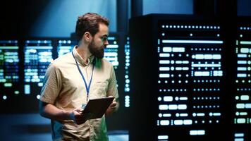 Repairman in server farm walking through mainframes used for computationally intensive tasks such as scientific simulations or 3D rendering. Professional doing routine equipment inspection photo