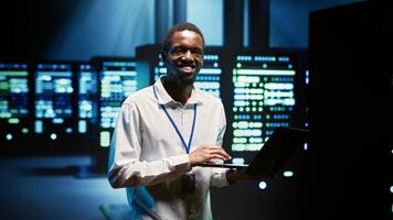 Technician making sure high tech facility data servers are appropriately equipped to provide redundancy, automatic failover and rapid reconfiguration of clusters to minimize failure of individual rigs photo