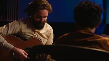 talentoso artista haciendo En Vivo actuación con su guitarra en profesional estudio, grabación nuevo canciones con su audio experto. sonido ingeniero mezcla y dominar pistas para a él. cámara una. foto