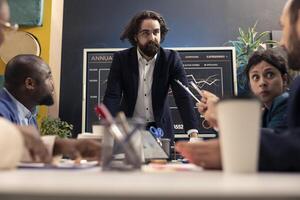 Business associates working together on new project in a boardroom, reviewing success metrics and key performance indicators to measure productivity. Colleagues accomplishing enterprise goals. photo