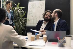 Enterprise colleagues discussing project updates and details in meeting room, establishing resources allocation and other tasks to achieve business goals, corporation operations. photo