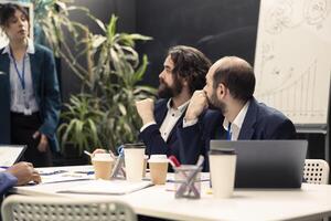 Focused project team working on annual reports during a briefing meeting, detecting what to improve in order to guarantee customer experience and satisfaction. Enterprise development. photo