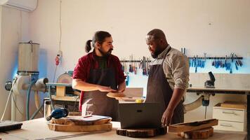 carpintero y africano americano compañero de trabajo verificando terminado madera Arte producto antes de enviando eso a cliente. artesano y aprendiz inspeccionando de madera objeto a corresponder a requisitos foto