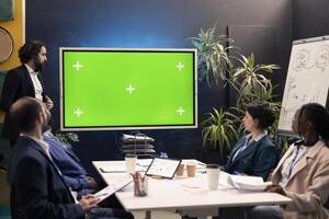 Corporate team using greenscreen interactive board display in a workshop meeting, working to improve their skills and productivity. Business workers prepare for successful collaboration. photo