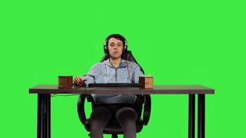 Woman being excited about winning online gaming championship, playing games on computer sitting at desk. Gamer having fun celebrating her success and victory, greenscreen backdrop. Camera B. photo