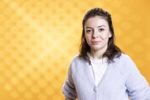 Portrait of smiling woman posing, feeling happy and relaxed, isolated over yellow studio background. Lively radiant caucasian person feeling carefree and upbeat, close up shot photo
