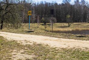 Shot of the street in the russian village. Signboard says no swimming. Outdoors photo