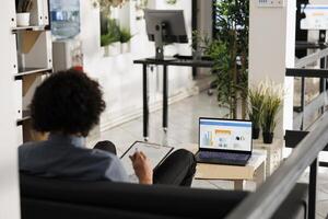 Arab businessman analyzing financial data on laptop screen in startup office. Executive manager comparing sales metrics and checking investment revenue statistics in coworking space photo