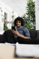 Arab business company worker messaging on smartphone in start up office. Young project manager talking with coworkers online in corporate chat using mobile phone at workplace photo