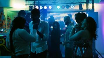 romántico personas bailando en pares en danza piso, ir de fiesta con lento música a discoteca. alegre parejas disfrutando danza fiesta con etapa luces y bebidas, entretenimiento evento. Mano disparo. foto