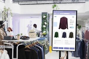 Touch screen monitor kiosk service, modern fashion collection and products on interactive board in mall store. Electronic self ordering display of online clothes shop, business concept. photo