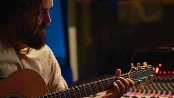 experto artista canto en su guitarra y grabación melodías para un futuro canción, trabajando en nuevo álbum en controlar habitación a estudio. músico compositor creando un nuevo pista o9n instrumento. cámara una. foto