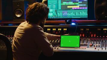 Audio technician working with music recording software and editing tunes, mixing console and control panel board in post production studio. Producer operating technical equipment. Camera A. photo