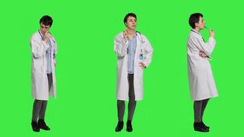 General practitioner thinking about new healthcare ideas in studio, acting pensive against greenscreen backdrop. Woman medic contemplating about ways to find disease cures. Camera A. photo