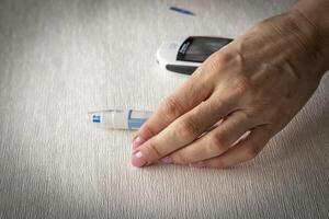 Close up shot of the glucometer instrument on the white surface. Healthcare photo