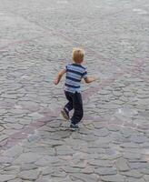 Shot of the little boy running on the streets. Concept photo