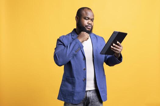 Accountant doing profit analysis for company using tablet, isolated over studio background. Worker doing financial budgeting and forecasting on portable device, solving business tasks photo