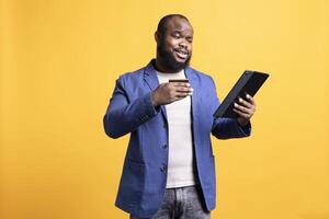 African american man adding payment method on website, isolated over studio background. Cheerful man excited to do online shopping, carefully typing credit card information photo