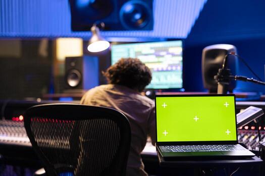 Musician and sound engineer working on a new song with isolated screen, editing and adjusting volume levels on tunes recorded. Team of artists producing music and composing tracks in control room. photo