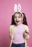 Young joyful toddler being surprised by easter festivity in studio, feeling excited about toys and celebrating spring event. Little enthusiastic kid being positive about april celebration. photo