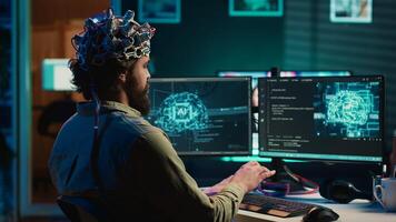 Man with EEG headset on writing code allowing him to transfer mind into computer virtual world, becoming one with AI. Transhumanist using neuroscientific technology to transcend, camera A photo
