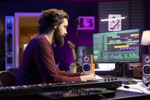 Musical composer writing a song with new lyrics in home studio, recording tunes with audio equipment gear. Singer songwriter takes notes to compose words and melodic elements, producing music. photo