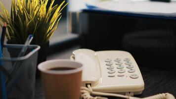 Cup of coffee on office desk next to paperwork containing business financial information income statements, close up shot. Company invoice documents and hot beverage in accounting workspace photo