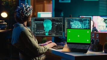 computadora científico subiendo cerebro dentro ciberespacio, ganando digital persona utilizando verde pantalla ordenador portátil. neurocientífico fusionando mente con ai, subiendo conciencia dentro croma llave dispositivo, cámara un foto