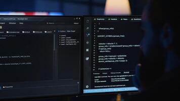 Software engineer writes complex binary code scripts on computer, close up. Teleworking IT specialist in home office using programming to safeguard consumer data, handheld camera shot, camera A photo