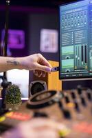 Talented producer using an usb stick to edit recorded audio files in home studio, working in post production. Young sound engineer adding audio effects mixing and mastering tunes, daw software. photo