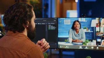 Teleworking software engineer talking with colleagues during internet videocall, discussing ways to fix programming bugs. IT admin in videoconference meeting with coworkers, camera A photo