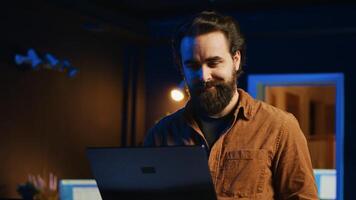 Focused computer scientist writing complex binary code scripts on laptop terminal. Remote IT support worker standing in home office, using programming to safeguard consumer data photo