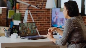 Teleworking team leader in cozy apartment discussing with coworkers during videoconference meeting. Company manager at home holding online videocall with workers, camera B photo