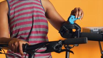 Technician setting up bike repair stand, using it to adjust derailleur and cables, mending damaged wheels, close up shot. Specialist assembling workstand to do bicycle maintenance, camera A photo