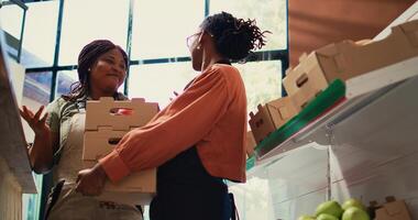 Encargado de tienda recepción Fresco suministros desde local granja, promoviendo eco simpático pequeño negocio. mujer proveedor trayendo éticamente de origen frutas y verduras, orgánico mercancías. Mano disparo. foto