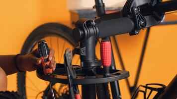 Close up shot of repairman preparing work tools before starting mending broken customer bicycle, studio background. Expert arranging mechanical gear, ready to start servicing bike, camera A photo