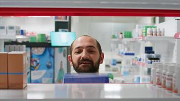 pov de farmacéutico colocación medicamentos cajas en estantes, organizando tipos de medicina en farmacia. médico asistente poniendo suplementos o tratos en prescripción, seguro servicios. trípode disparo. foto