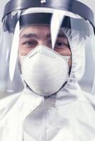 Sad medical technician wearing ppe uniform with face shield Overworked researcher dressed in protective suit against invection with coronavirus during global epidemic. photo