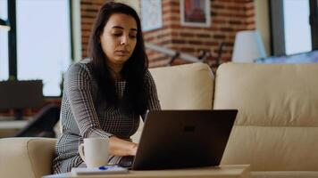 Portrait of happy remote worker enjoying stay at home freelancing job, solving tasks in stylish cozy apartment. Focused smiling teleworker working from home, typing on laptop keyboard photo