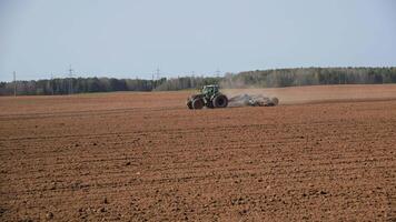 traktor kultivator eller såmaskin plogar de landa, förbereder för gröda. damm på fält video