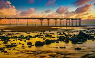 el muelle a puesta de sol en el costa de quemadura de sal con rocas en primer plano foto