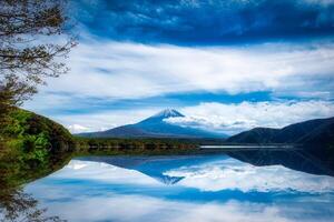 Landscape image of Mt. Fuji over Lake Motosu with autumn foliage at daytime in Yamanashi, Japan. photo