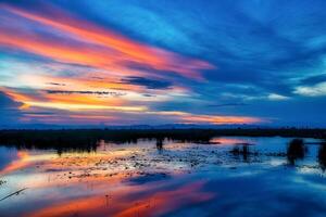 Dramatic sunset sky with clouds over mountian and lagoon photo