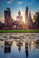 grande Buda a puesta de sol en wat mahathat templo, sukhothai histórico parque, tailandia foto