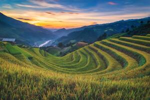 arroz campos en aterrazado con de madera pabellón a puesta de sol en mu cang Chai, yenbai, Vietnam. foto