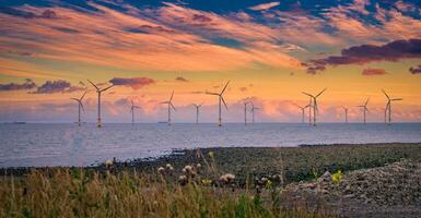costa afuera viento turbina en un Granja eólica debajo construcción apagado el Inglaterra costa a puesta de sol foto